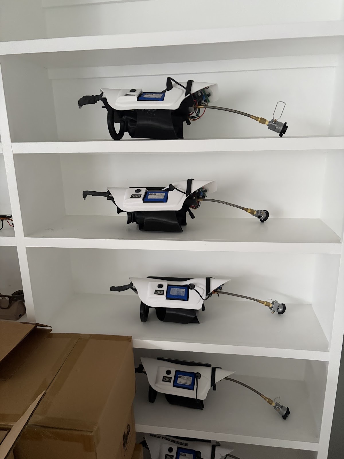 Flamethrower units lined up on white shelves