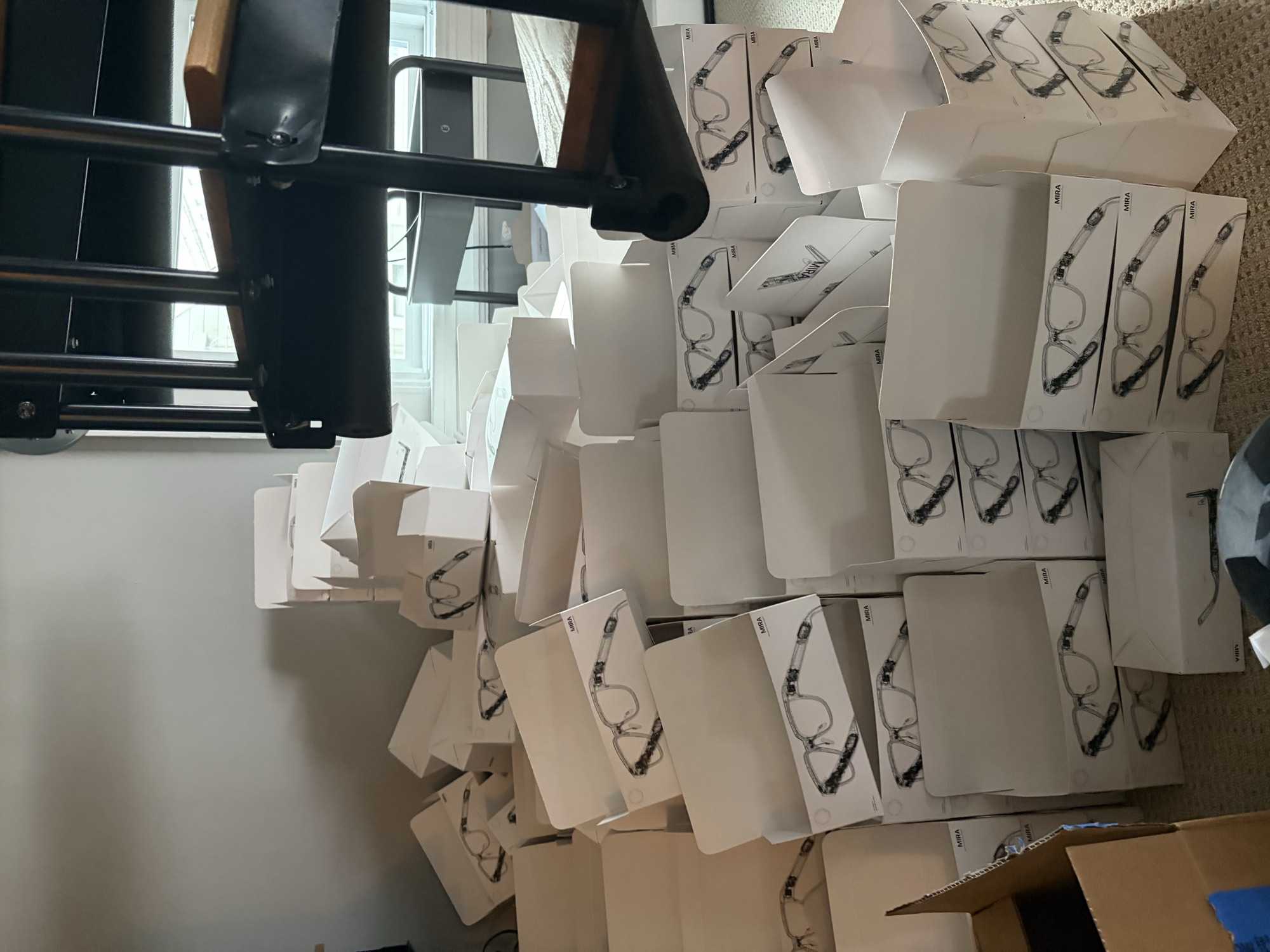 A living-room floor covered in white Mira boxes waiting to be packed