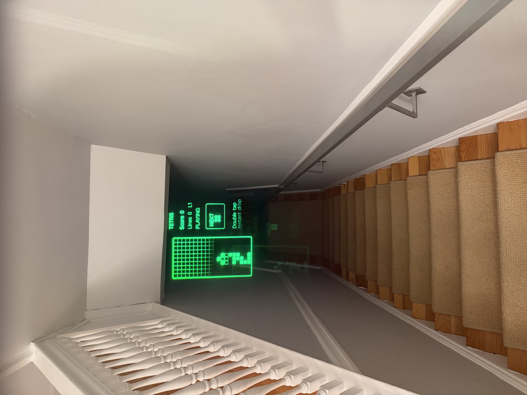 Tetris projected in green through the glasses, hovering over a stairwell